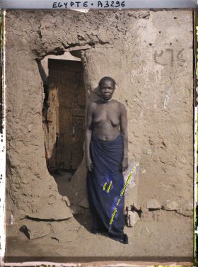 Image représentant Femme aux seins nus dans une rue du village