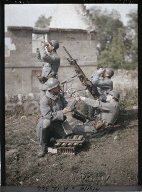 Image représentant Quatre soldats d'une section de mitrailleurs en situation de tir avec une mitrailleuse de type Saint-Etienne