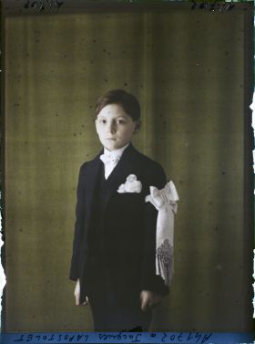 Image représentant https://musee-albert-kahn.s-museum.fr/home/NWQ2OTAwYzNmYjZlZTk1ZWQwODJmMjY4L2dlbmVyaWMtbm90aWNlLXRhYi9hdXRob3JpdHkvNjE3YTc5ZjVjZjhiODk2OGIzMzM3ZDIx/5d6900c3fb6ee95ed082f268/generic-notice-tab/authority/617a79ebcf8b8968b3337127 L'enfant Jacques Lapostolet en communiant