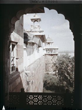 Image représentant Vue sur l'extérieur de l'enceinte du fort Rouge (Lal Qila), la toiture du palais privé (Khas Mahal) surmontée d'un chhatri et au fond, la tour du Jasmin (Musamman Burj)