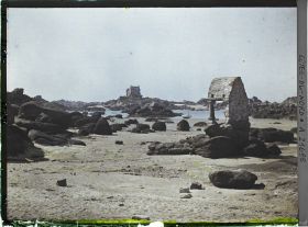 Image représentant L'oratoire de Saint-Guirec à marée basse ; à l'arrière-plan, le château de Costaéres
