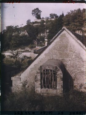 Image représentant Puits près du toit d'un maison, au fond les habitations troglodyte