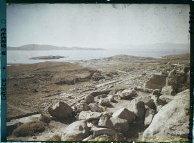 Image représentant Panorama vers les ruines de la ville antique (haute et basse) et la mer, depuis l'antre du Cynthe sur le versant occidental du mont Cynthe (au fond, l'Ile de Syros)