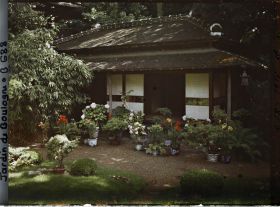 Image représentant Maison est du " village japonais ", ornée d'érables, de cannas et d'hortensias en pots