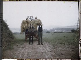 Image représentant Agriculteur près d'une charrette de fourage, accompagné de jeunes gens