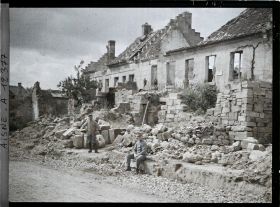 Image représentant Deux soldats devant des maisons détruites
