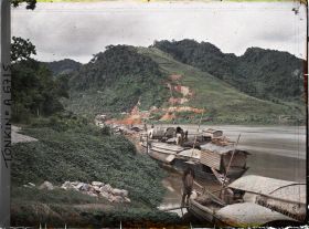 Image représentant Des sampans ancrés au bord de la rivière Claire, à l'arrière-plan, les mines de zinc de Trang-da