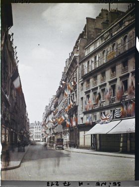 Image représentant La rue des Capucines vue de la rue de la Paix et décorée des drapeaux alliés pour les fêtes de la Victoire des 13 et 14 juillet 1919