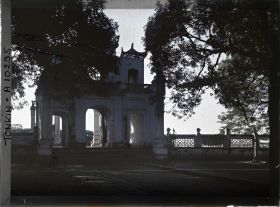 Image représentant Le portique d'entrée vu en contre-jour depuis l'intérieur de la cour plantée de manguiers, du temple de Chan-vu (ou Tran-vu)