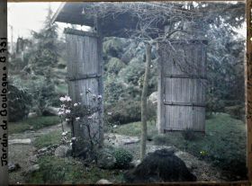 Image représentant Arbre et arbuste devant la porte du " village japonais " ouvrant sur le " sanctuaire japonais "