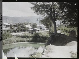 Image représentant Ruines d'anciennes douves ou simple cours d'eau (?) et une partie de la ville