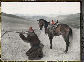 Image représentant Chasseur mongol descendu de cheval faisant une démonstration du maniement du fusil à pierre