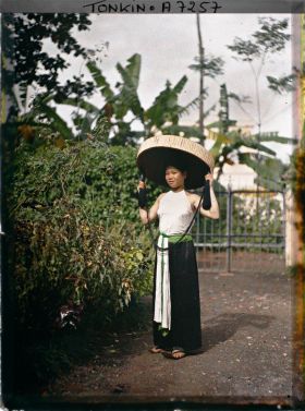 Image représentant Portrait d'une jeune femme de classe aisée en cache-sein, portant le grand chapeau en feuilles de latanier