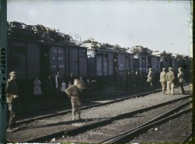 Image représentant Grecs quittant la ville, au pied d'un train chargé de mobilier