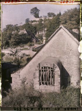 Image représentant Puits près du toit d'un maison, au fond les habitations troglodyte