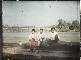 Image représentant Des enfants assis au bord de la douve protégeant l'enceinte extérieure du temple d'Angkor Vat