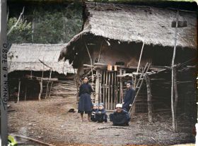 Image représentant Des villageois thaï (thô) devant leur habitation dans le massif de Bac-so'n (ou massif de Cai-binh)