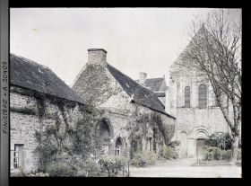 Image représentant Des bâtiments abbatiaux avec l'entrée de l'abbaye et à droite l'église abbatiale Notre-Dame