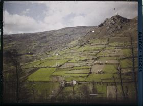 Image représentant Un versant cultivé avec de petites maisons dispersées ; à droite, une butte avec vieille tour de guet