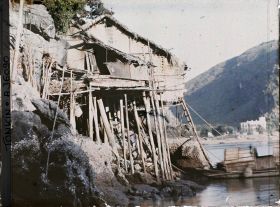 Image représentant Une maisons sur pilotis construites à flanc de rocher sur le rivage de l'île Cat-bà
