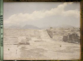 Image représentant Le palais dans la cour occidentale, les gradins d'un théâtre. Au centre, l'escalier nord. A droite, le grand escalier (menant aux grands Propylées)