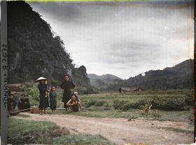 Image représentant Des marchands ambulants et des villageois thaï au bord d'un chemin du massif de Bac-so'n (ou massif De Cai-binh)