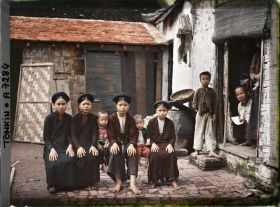 Image représentant Des jeunes filles et des enfants de classe aisée, assis sur un banc dans la cour intérieure d'une habitation