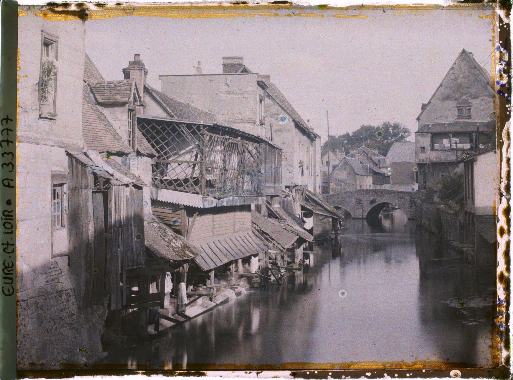 Image représentant Maisons anciennes et lavoirs au bord de l'Eure, au fond le pont Saint-Hilaire