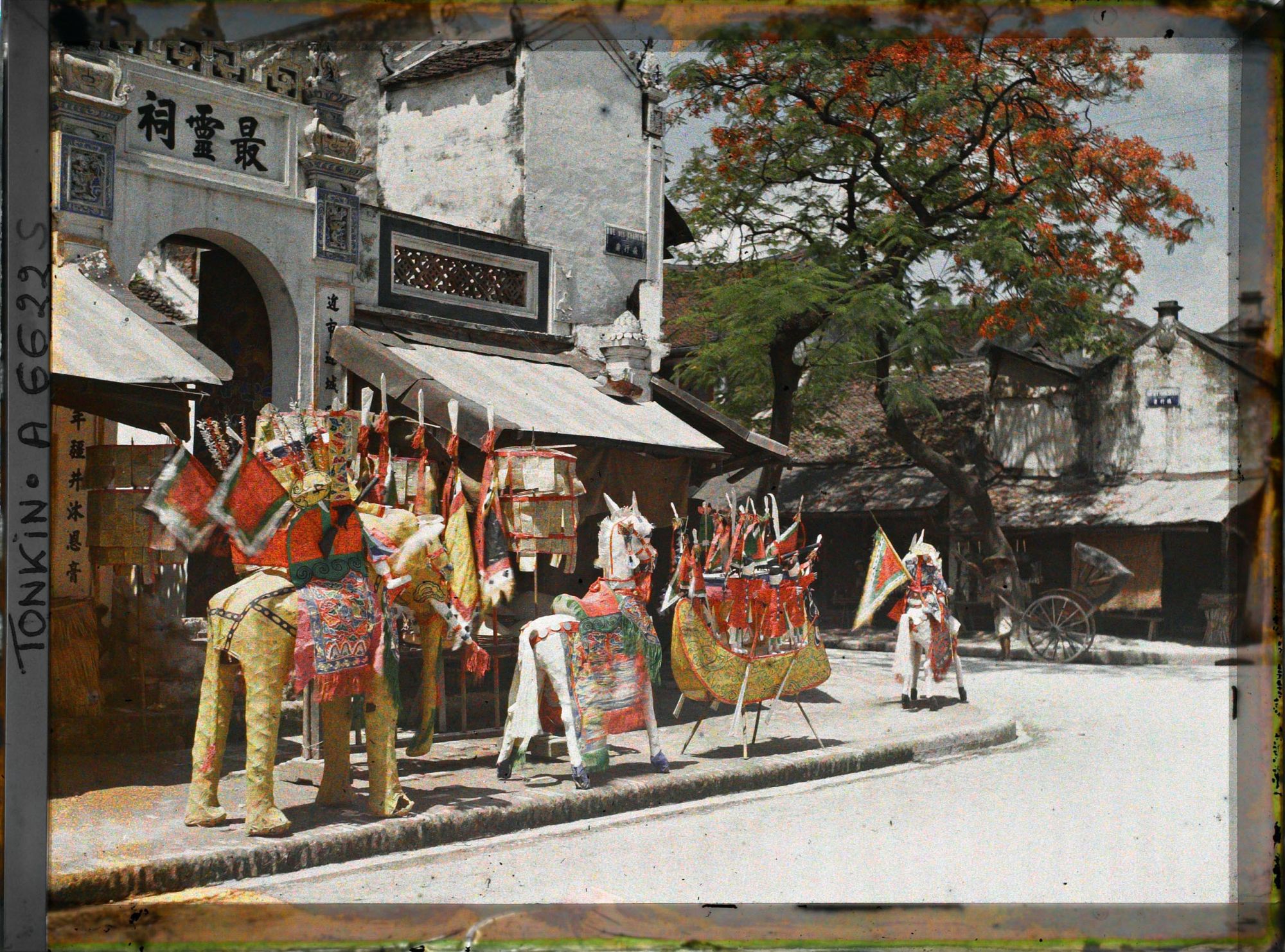 Image représentant Une exposition d'objets votifs en papier à l'entrée d'un temple, dans la " rue des Chapeaux "