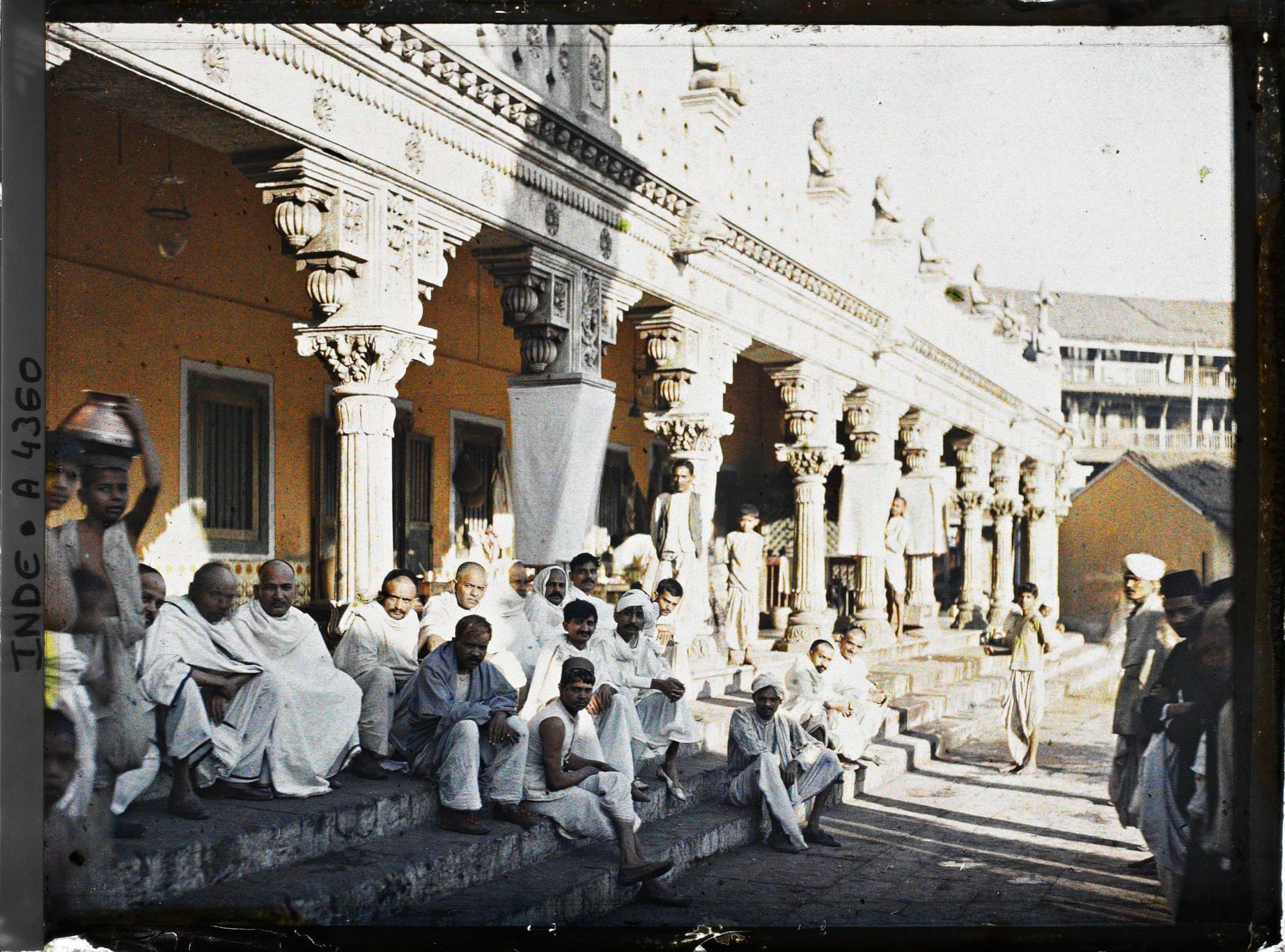 Image représentant Groupe d'hommes vêtus de blanc, assis sur les marches d'un temple hindou