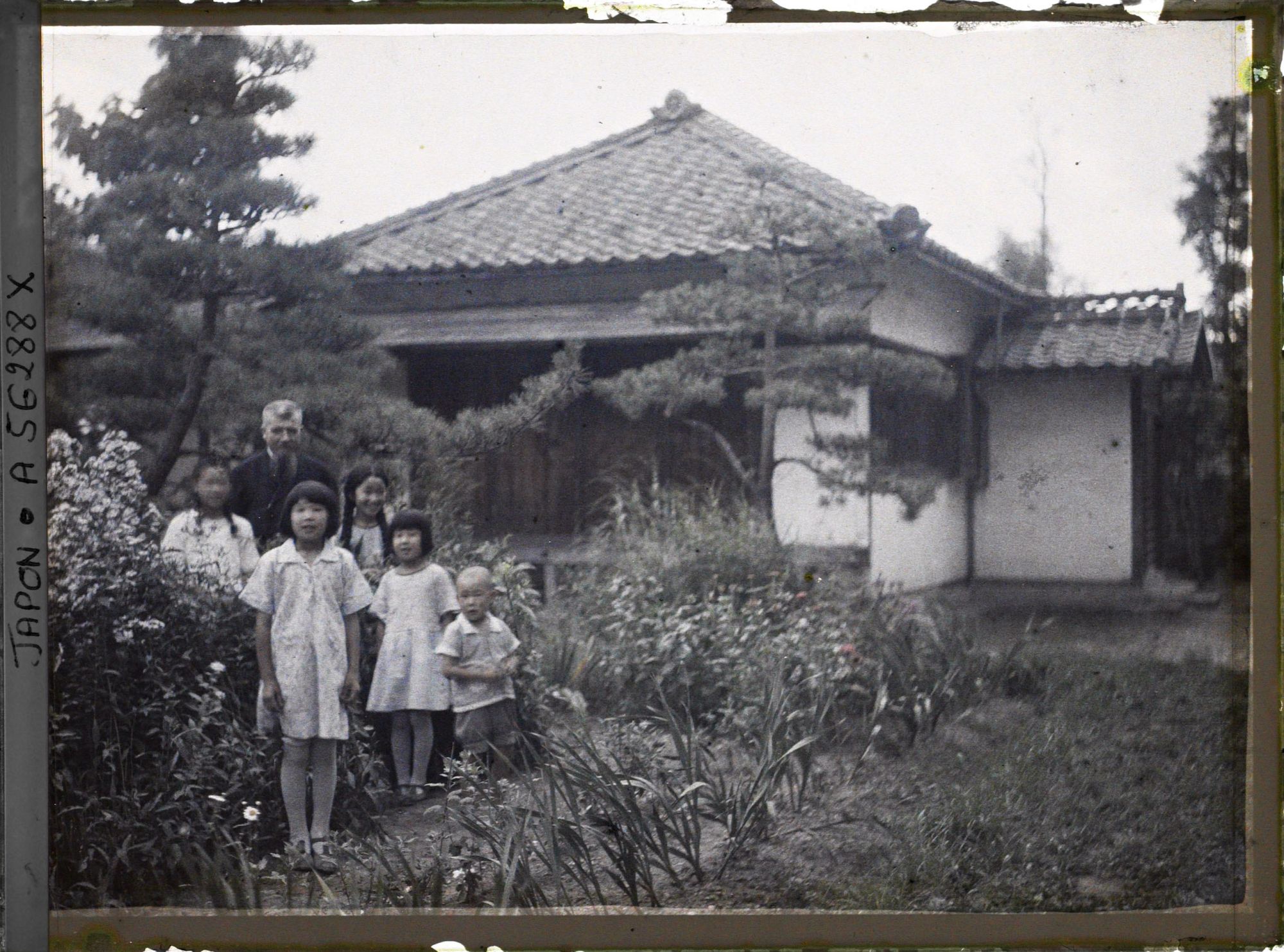 Image représentant Le père Cesselin, missionnaire français, entouré d'un groupe d'enfants vêtus à l'occidentale