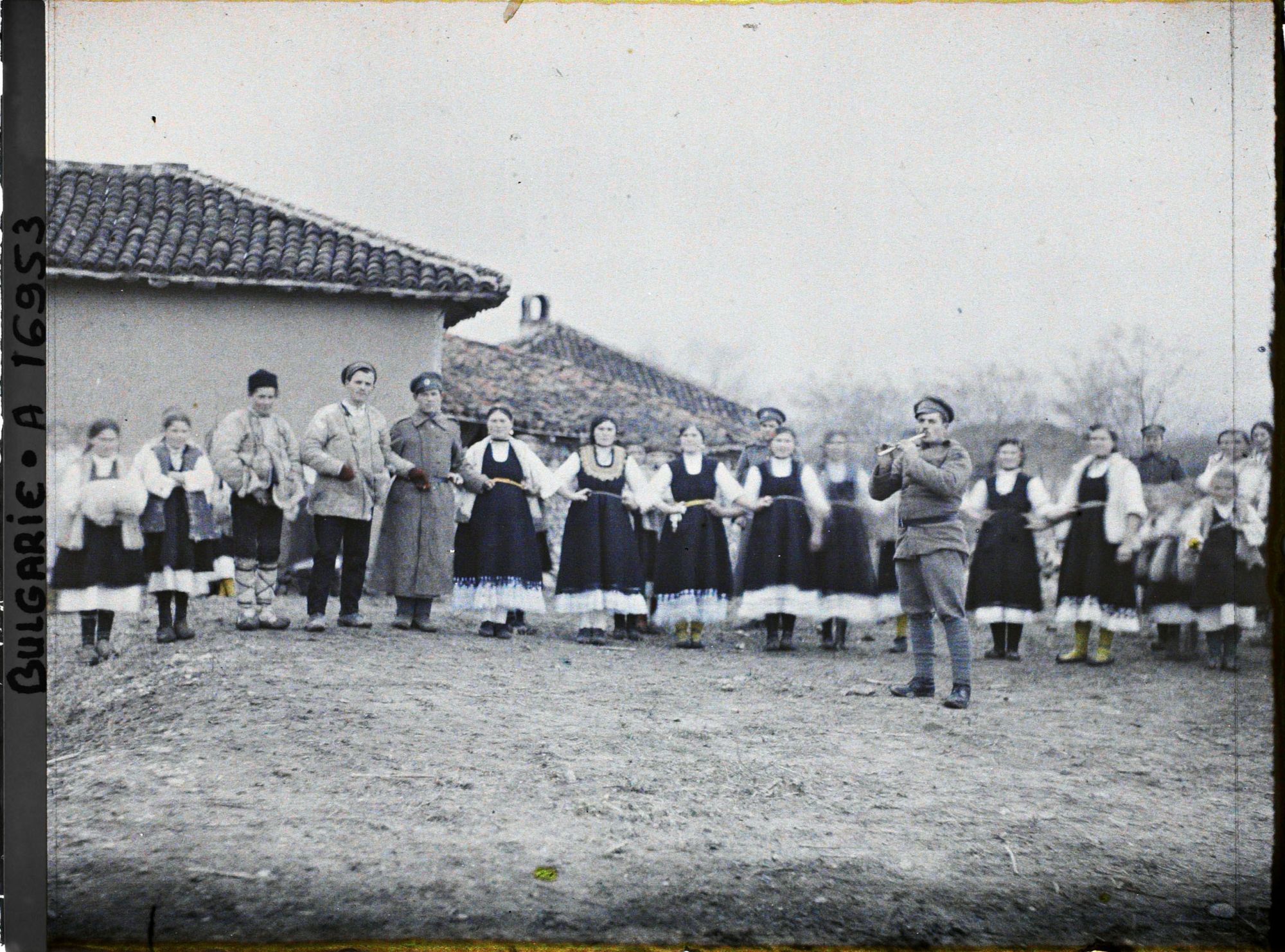 Image représentant Hommes, femmes, enfants et soldats exécutant une danse folklorique
