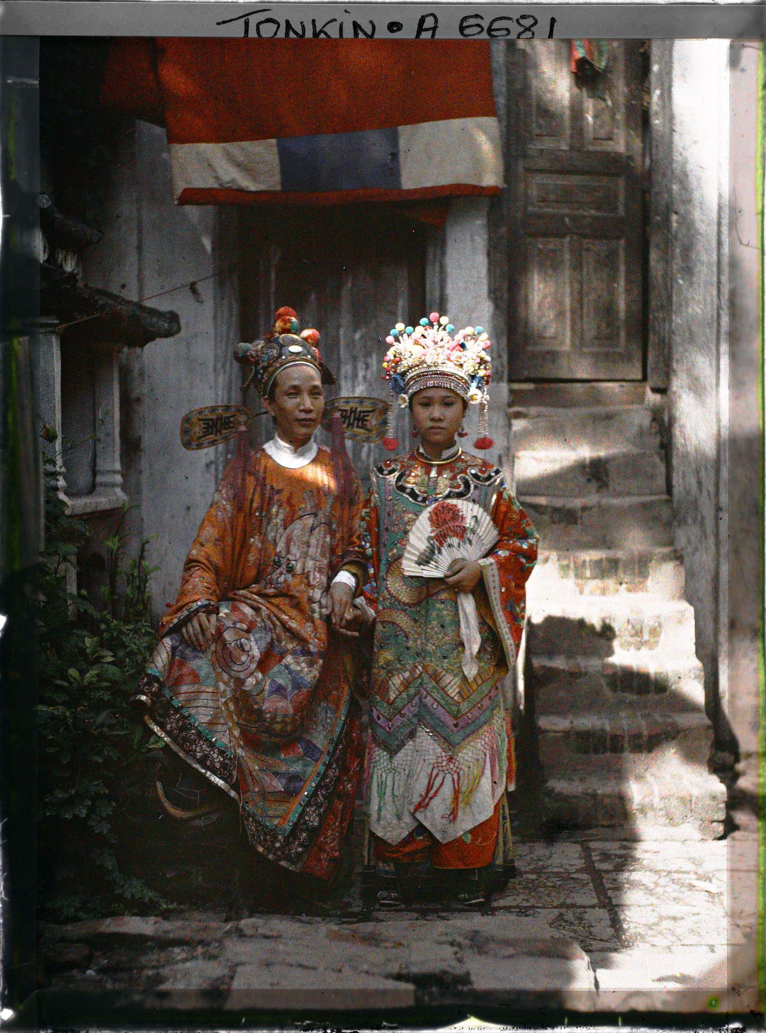 Image représentant Un couple d'acteurs du Théâtre Saïgonnais, en costume de scène, dans une cour intérieure