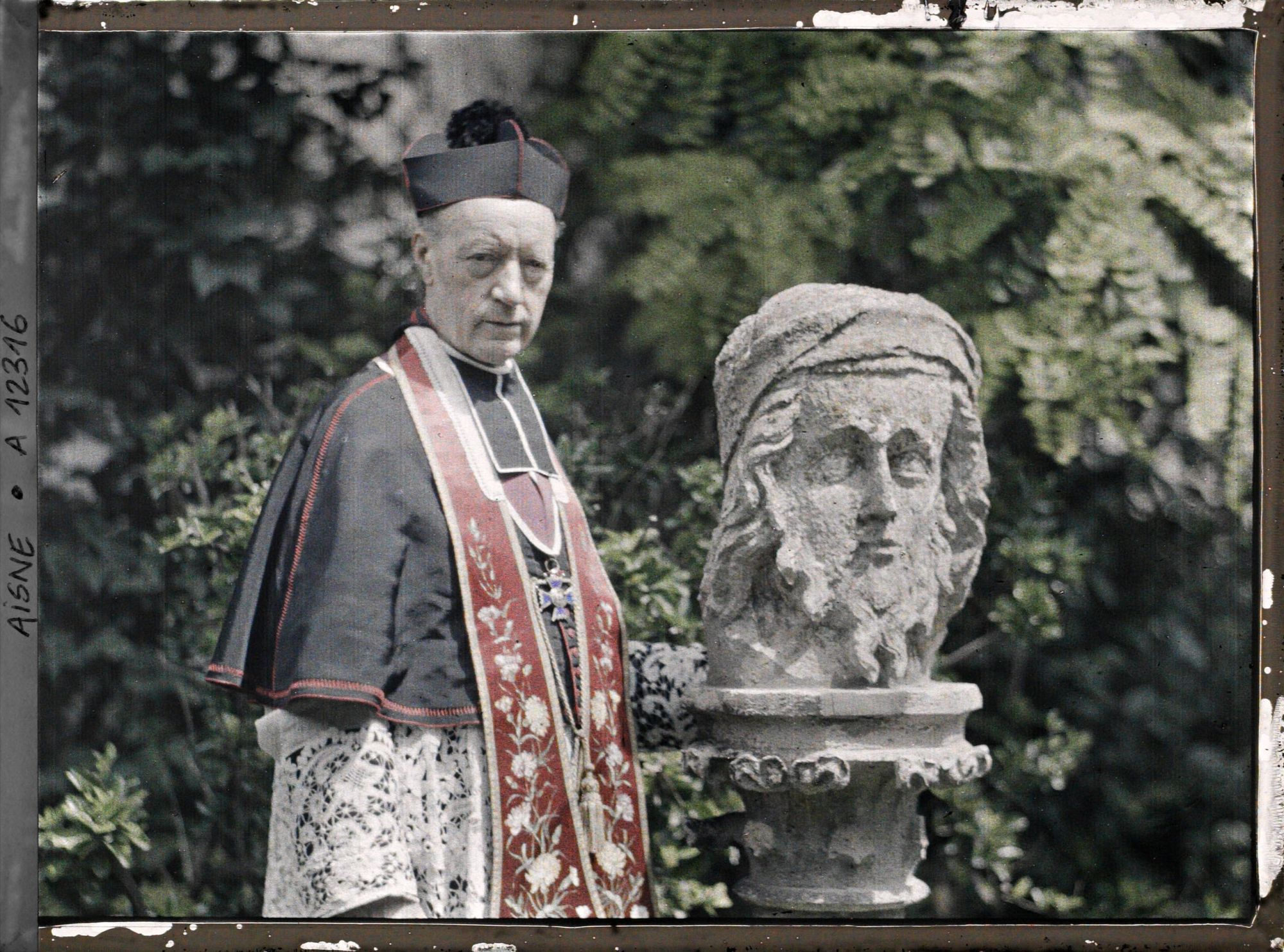 Image représentant Monseigneur Landais, archiprêtre de la cathédrale posant près d'une statue