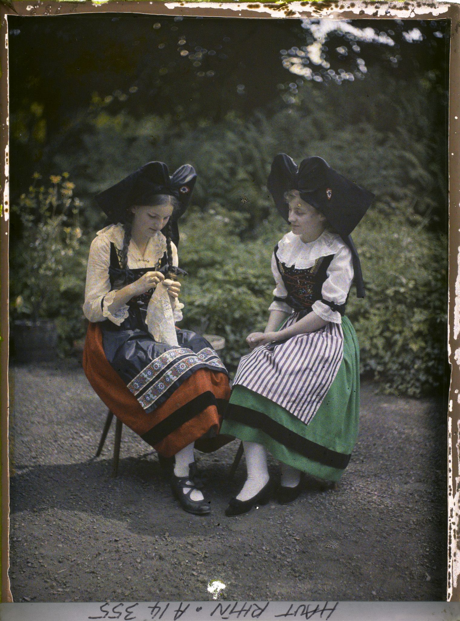 Image représentant Mlles Hélène et Denise Lauth (Hélène avec jupe rouge catholique, Denise avec jupe verte protestante)