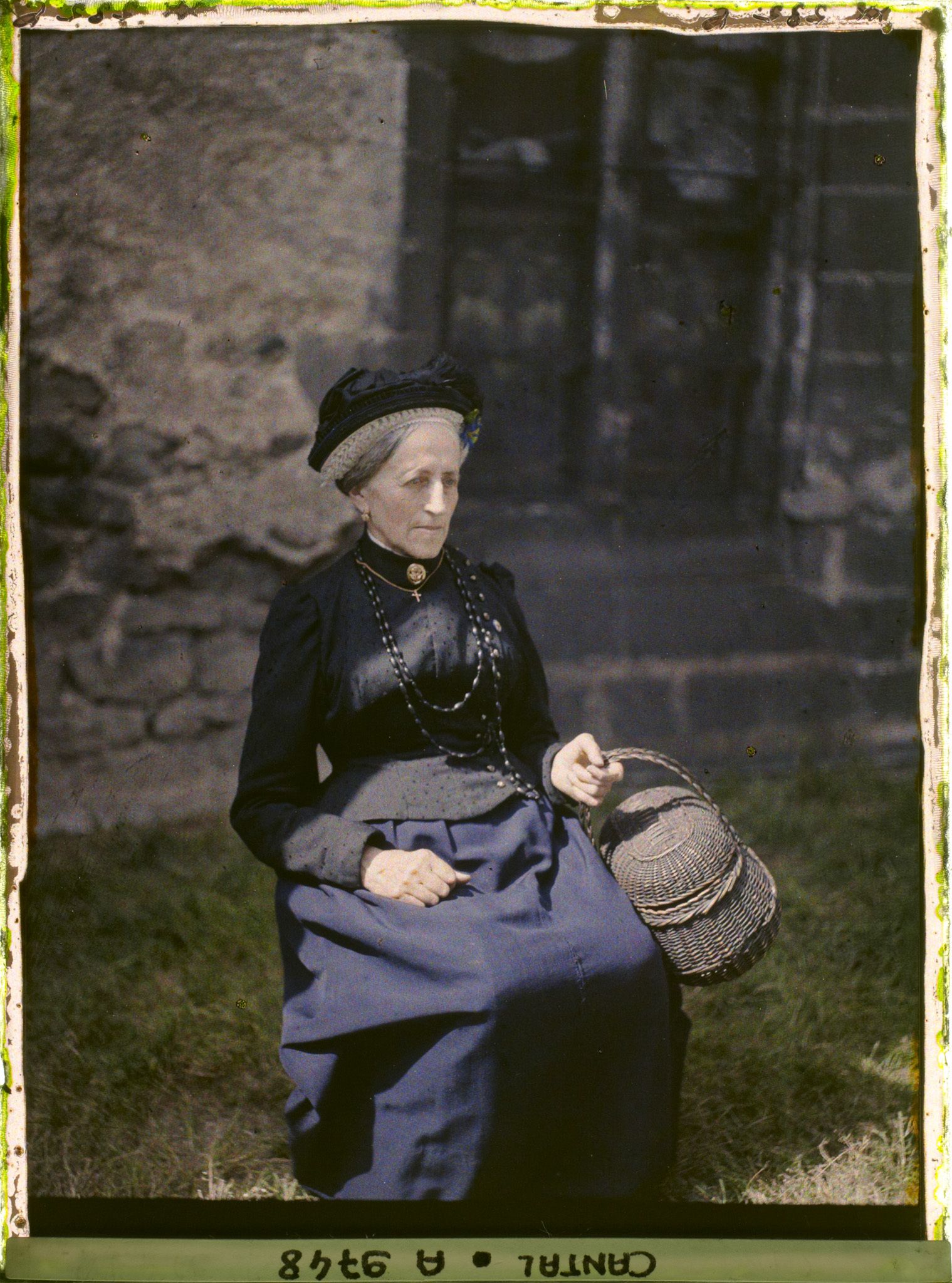 Image représentant Mademoiselle Maria Bérand assise, portant le chapeau de Saint-Flour