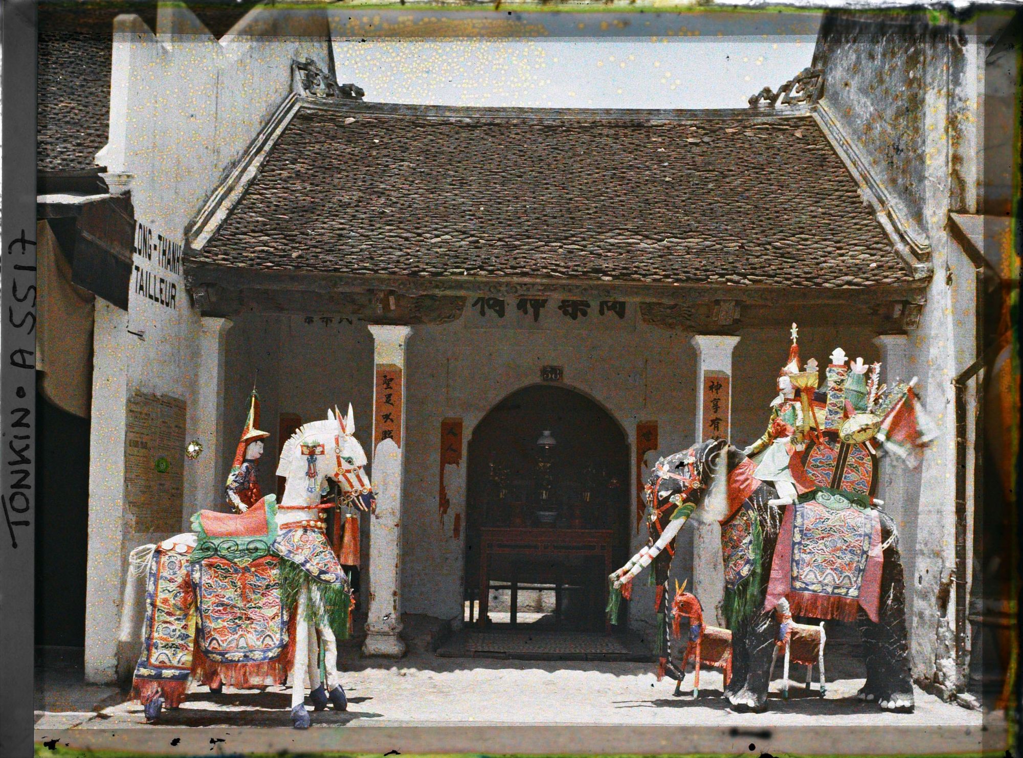 Image représentant Une exposition d'objets votifs en papier devant un petit temple du quartier sino-annamite
