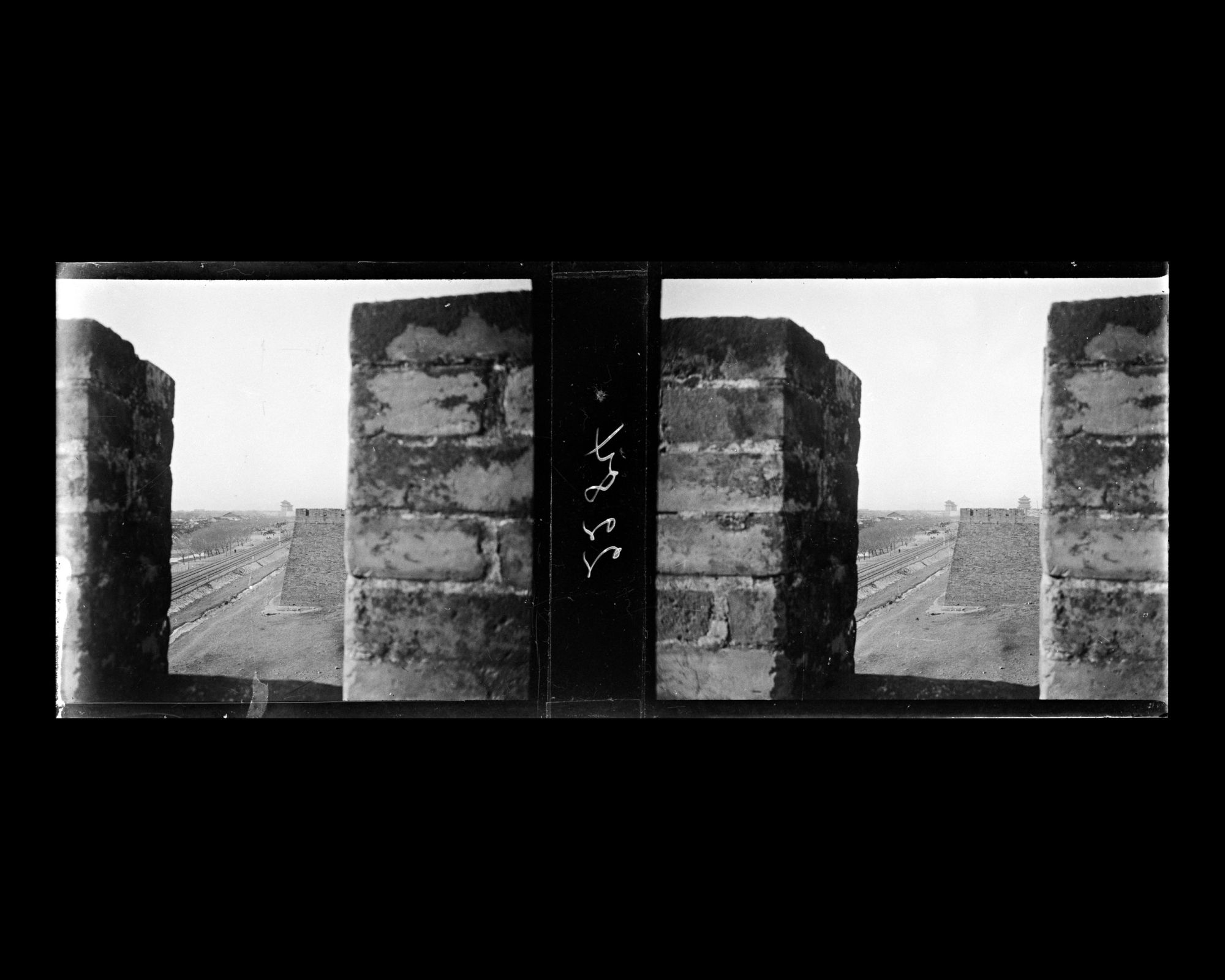 Image représentant Vue sur les voies ferrées de la ligne Pékin-Moukden et sur les douves bordées d'arbres, depuis L'enceinte sud de la ville tartare est, entre Zhengyangmen ("porte Face au Midi"), ou Qianmen ("porte Antérieure"), et Chongwenmen ("porte de la Vénération des Lettres"), ou Hadamen