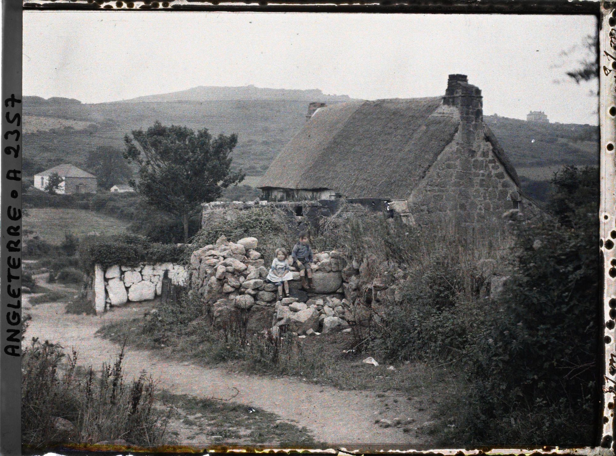Image représentant Deux enfants assis près d'une maison