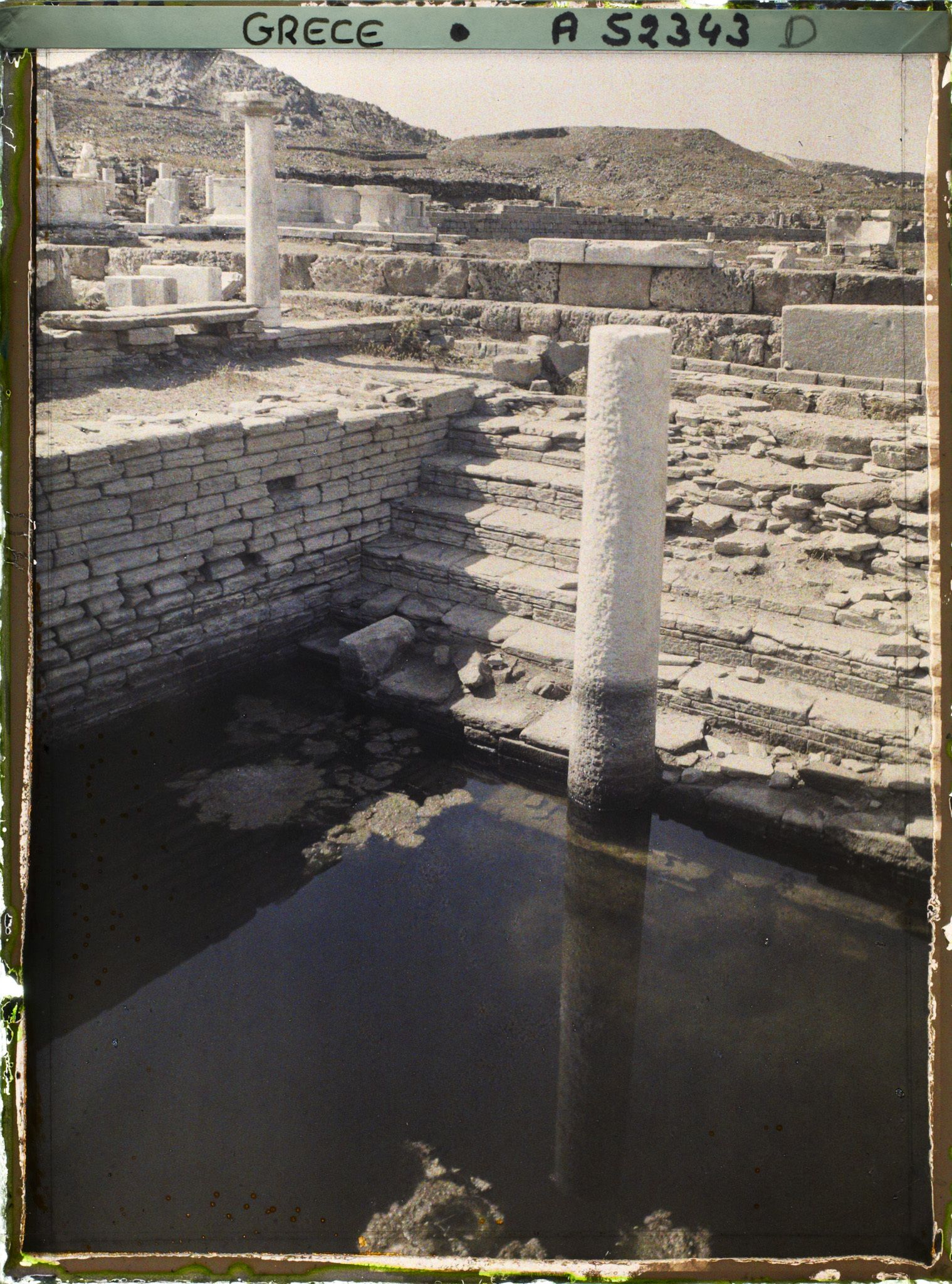 Image représentant Les Maisons au bord de la mer au fond, l'Ile de Tinos - La fontaine Minoé