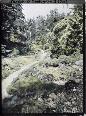 Image représentant Chemin du " sanctuaire japonais " menant au sorinto et rocaille fleurie ponctuée de conifères